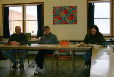 Mark Varvayanis and Jim Skaley listen to Kathy Zahler read a letter from County Legislator Martha Robertson.