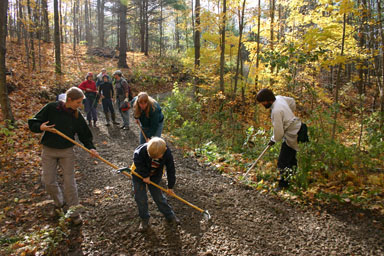 Raking fresh gravel to smooth out a trail