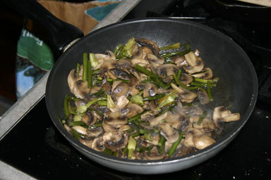 Garlic scapes cooking with mushrooms.