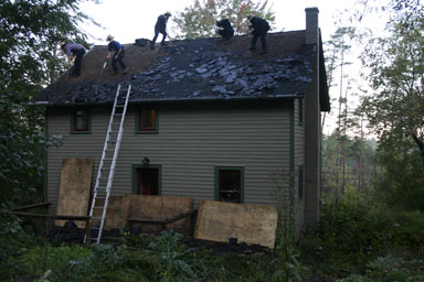 Tearing off two layers of asphalt roofing.