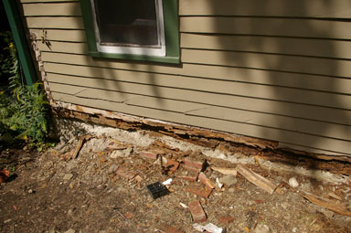 Rotten sill and crumbling concrete.