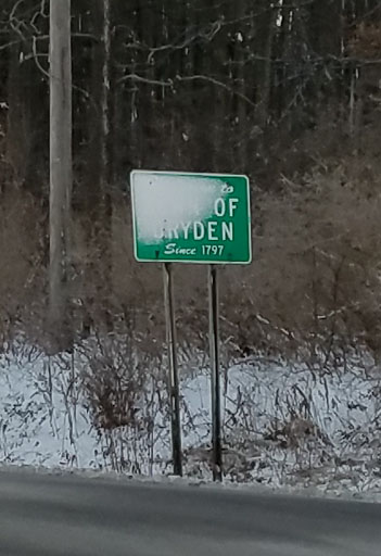 Plain Town of Dryden sign with snow.
